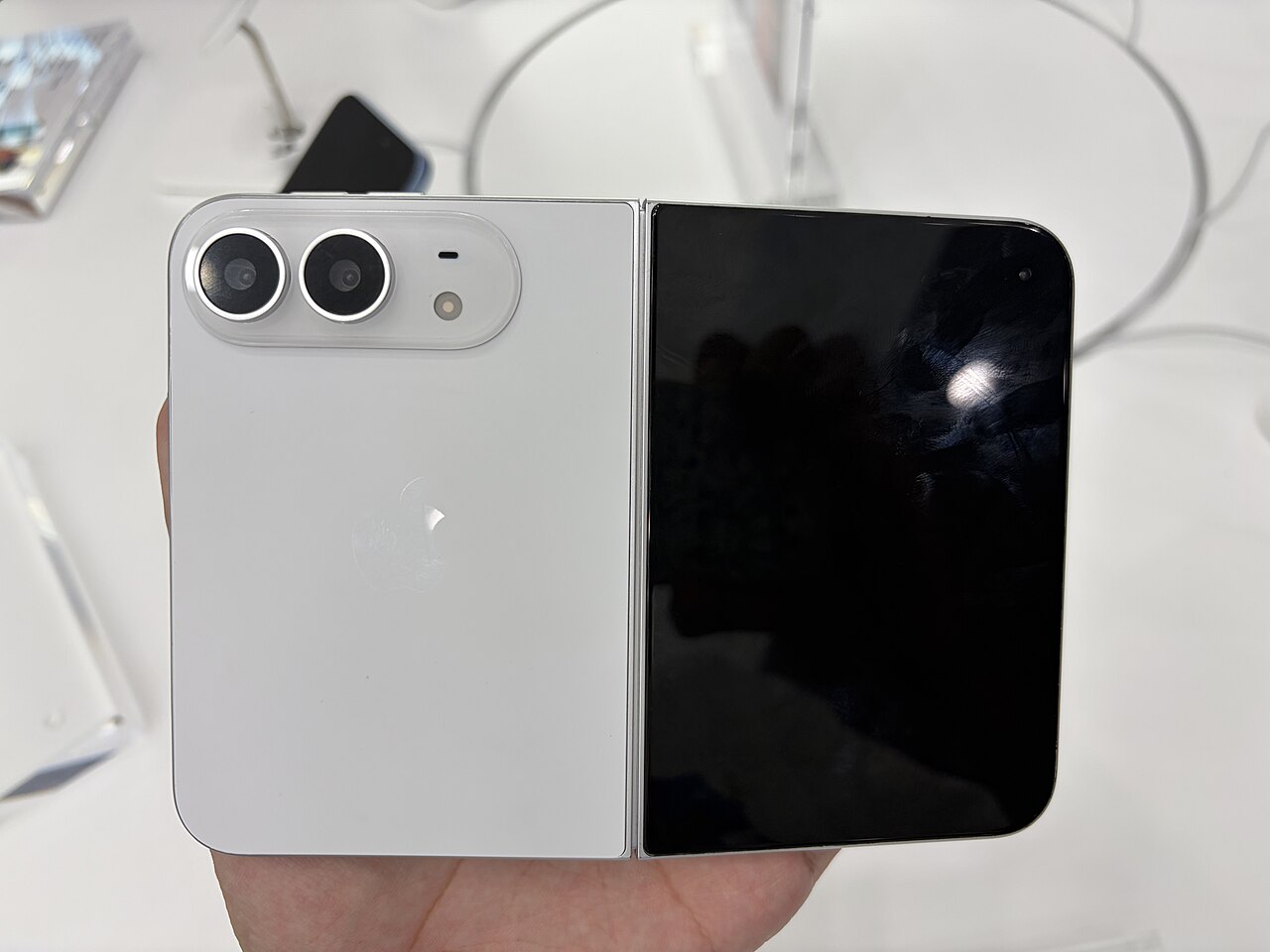 Star White iPhone Duo photographed partly open, showing two rear camera lenses side by side and the inner display